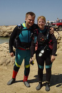 a young couple pose wearing diving equipment on their first scuba dive with a PADI Discover Scuba Diving Adventure in Cyprus