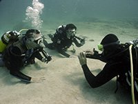 2 Divers practice new skills underwater with the scuba diving instructor