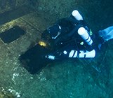 Rebreather diver using the Megalodon CCR looks into window on Zenobia wreck