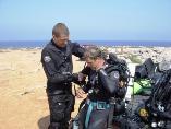 Technical Diving instructor helps rebreather student to put on the Megalodon CCR for the training course